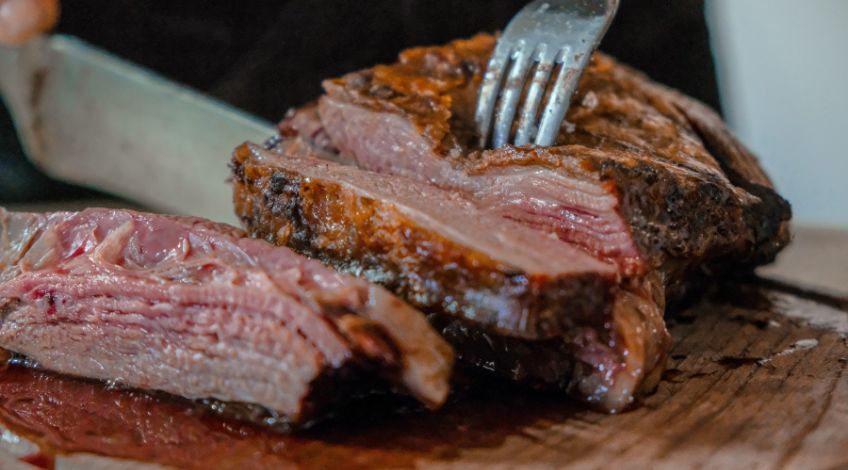 person slicing a meat