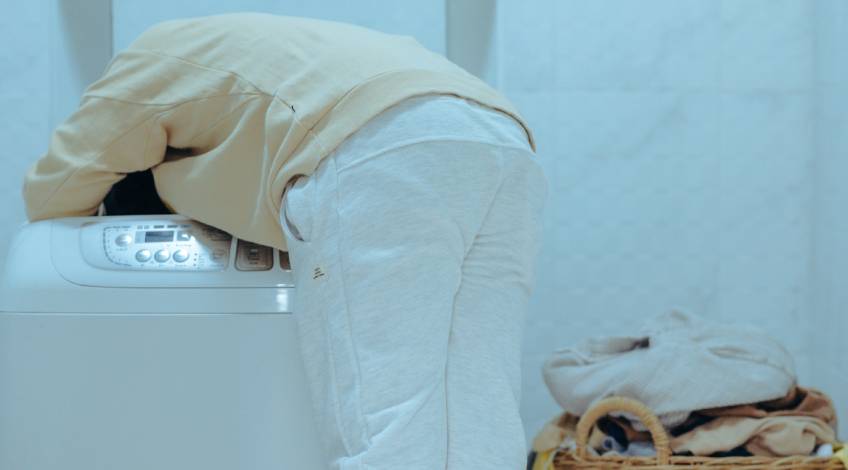 person checking the top load washing machine