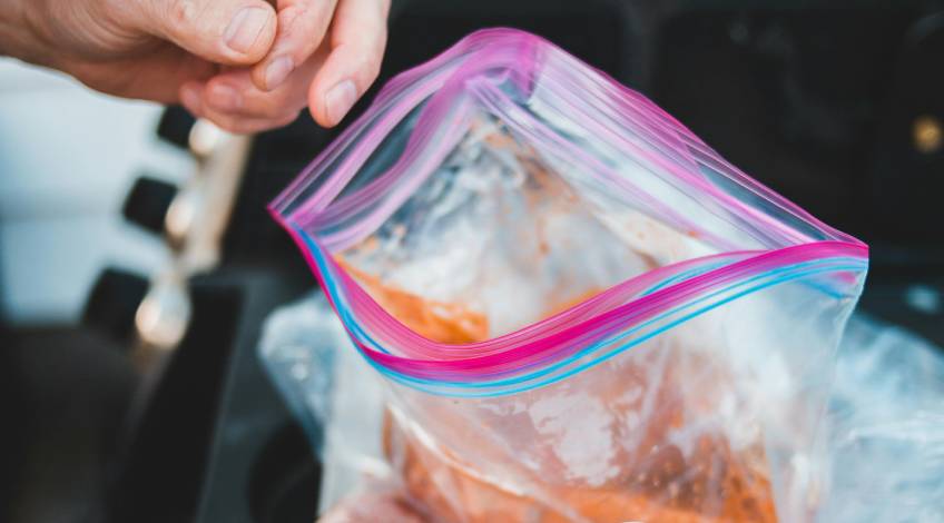 person putting food in a ziploc bag