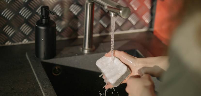 washing a sponge under running water