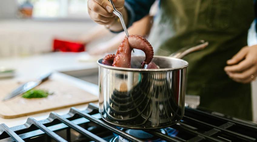 person cooking using stainless steel cookware