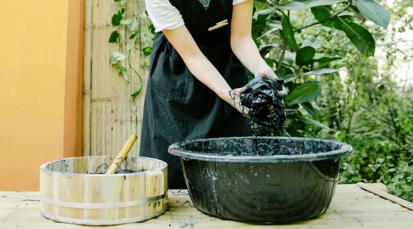 person using a black fabric dye