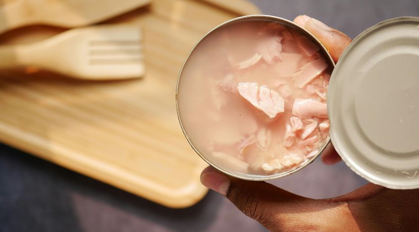 person holding an opened canned tuna