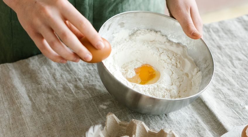 person cracking eggs