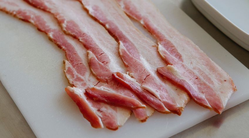 slices of bacon on a white chopping board