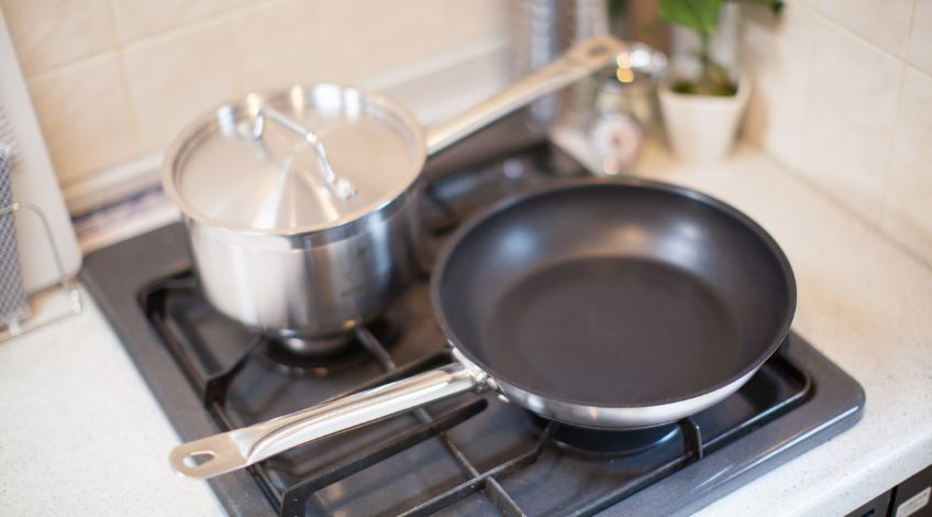 stainless steel pot and non stick frying pan on kitchen stove