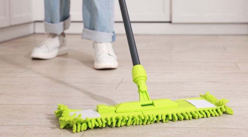 person cleaning floor with mop